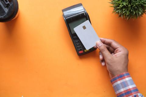 persona pagando con tarjeta de crédito en terminal
